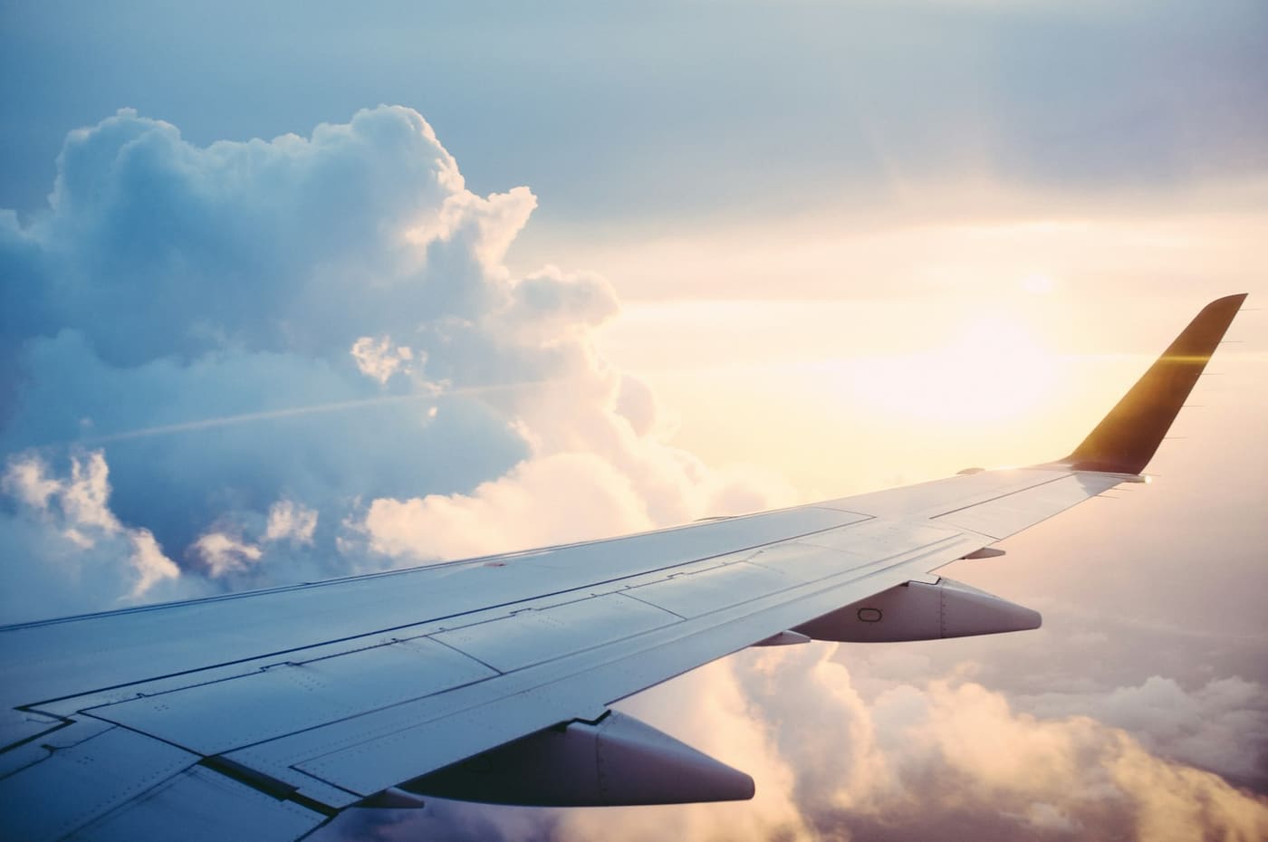 Aeroplane wing above the clouds at sunrise